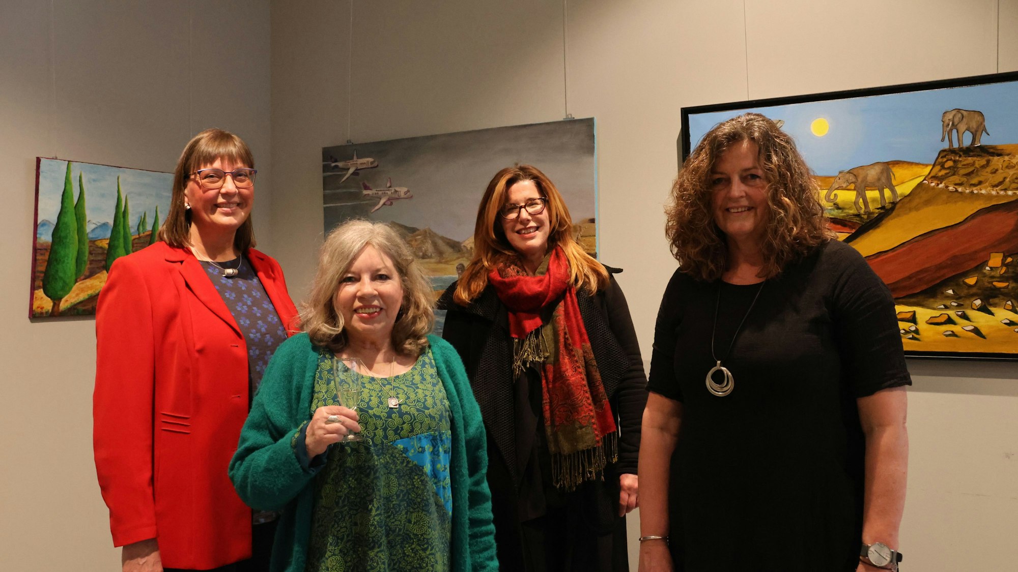 Die vier Künstlerinnen stehen vor ihren Werken und lächeln in die Kamera.