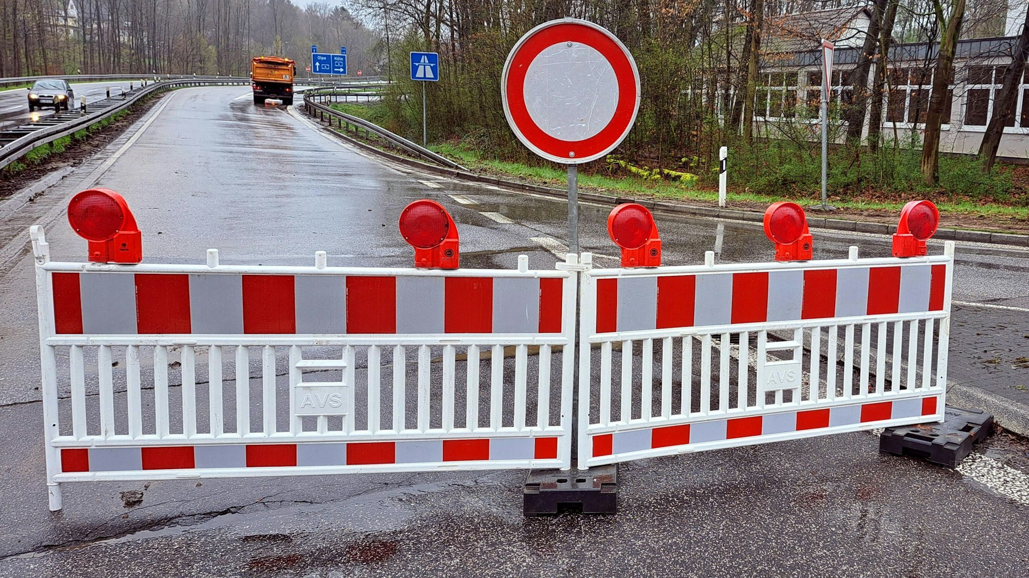 Eine rot-weiße Warnbake samt Durchfahrt-verboten-Schild versperrt die Zufahrt zur A4. Im Hintergrund ist ein Baufahrzeug zu sehen.