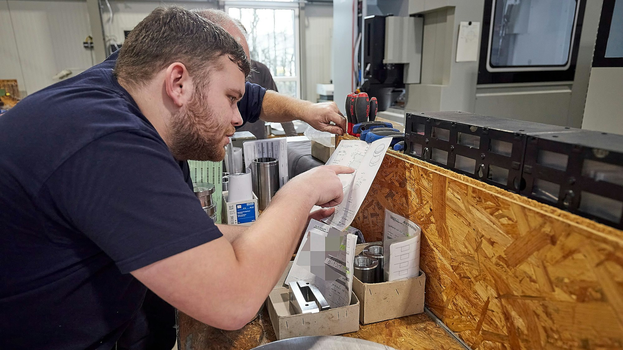 Genau hingeschaut: Die Produktion eines Werkzeugssatzes wird bei der Firma Sieber Forming Solutions vorbereitet. Zwei Mitarbeiter schauen sich den Plan an.