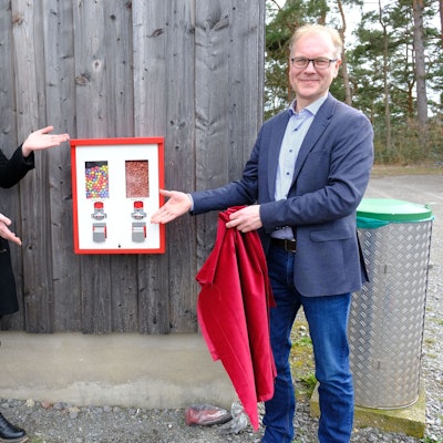 Museumsleiter Carsten Vorwig und Ann Heinen zeigen auf einen Kaugummiautomaten.