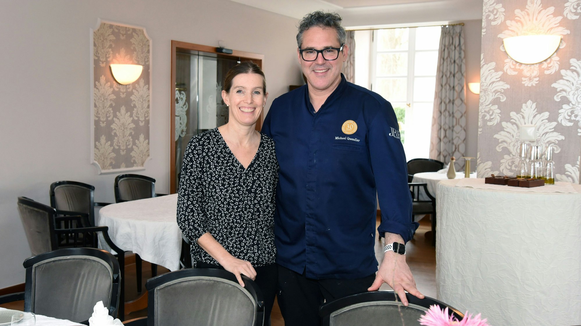 Ein Paar steht in seinem eigenen Restaurant nebeneinander.