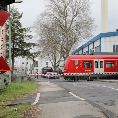 Eine S-Bahn fährt über einen Bahnübergang.
