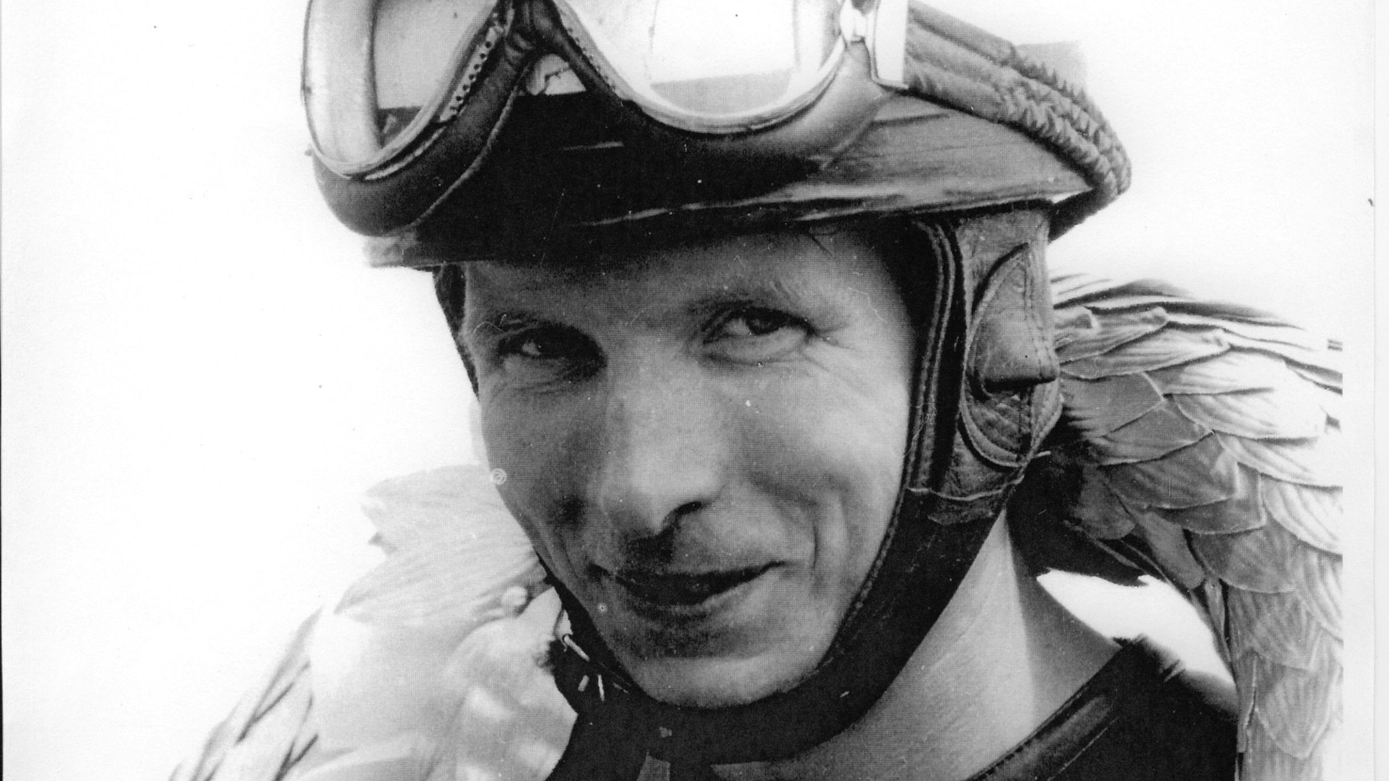 Ein Rennfahrer hat einen Lorbeerkranz umgehangen.