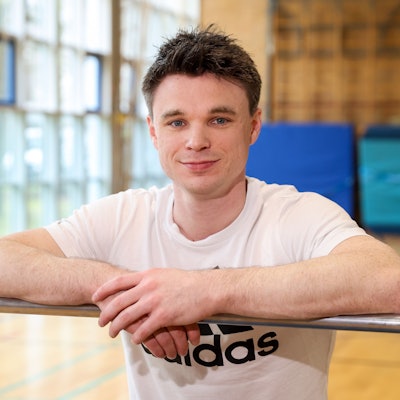 Jonas Rohleder von der Sporthochschule Köln lehnt an einer Trainingsstange