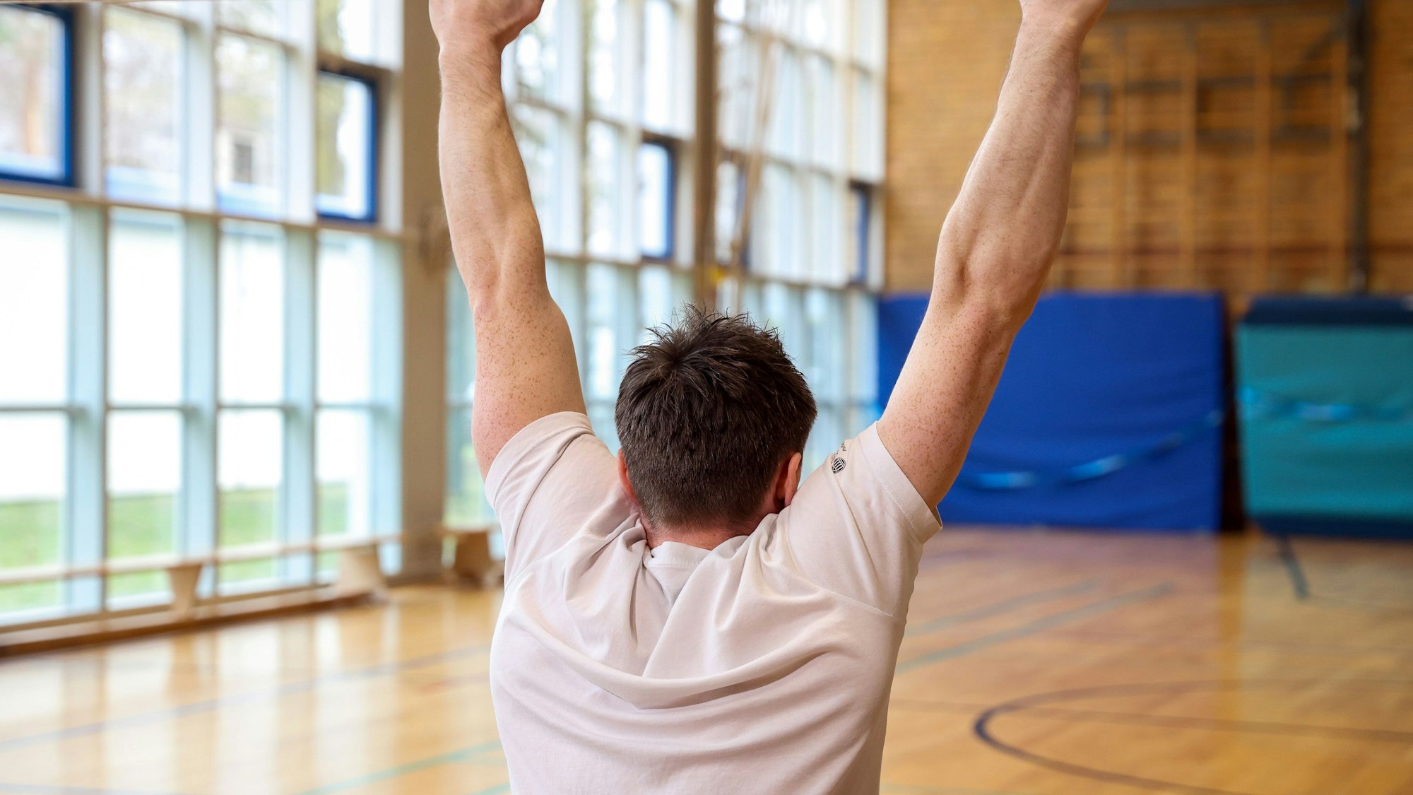 Jonas Rohleder zeigt eine Vorübung für den Klimmzug