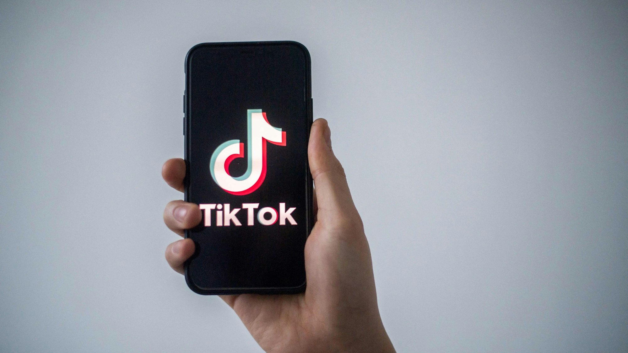 Es ist ein Handy zu sehen, auf dem TikTok steht.