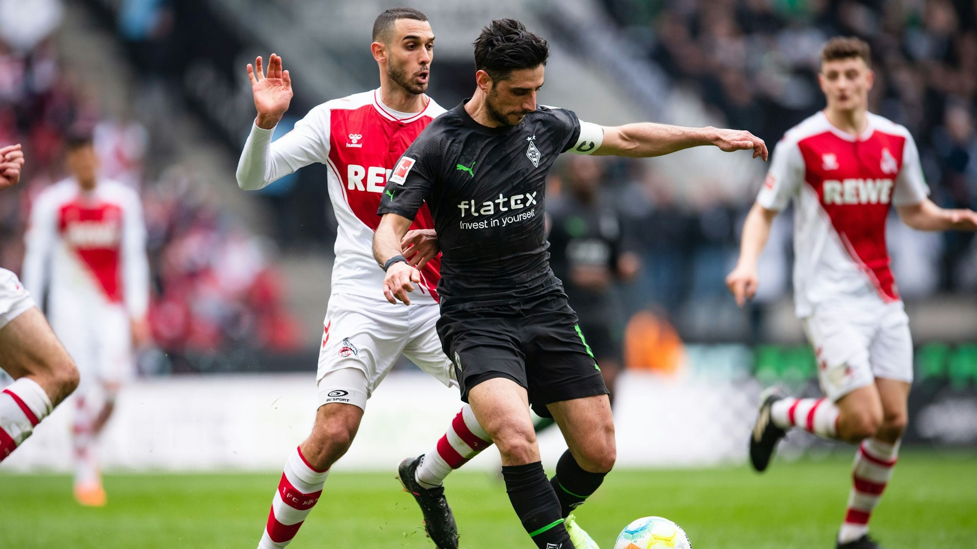 Kölns Ellyes Skhiri (l) und Gladbachs Lars Stindl kämpfen um den Ball.