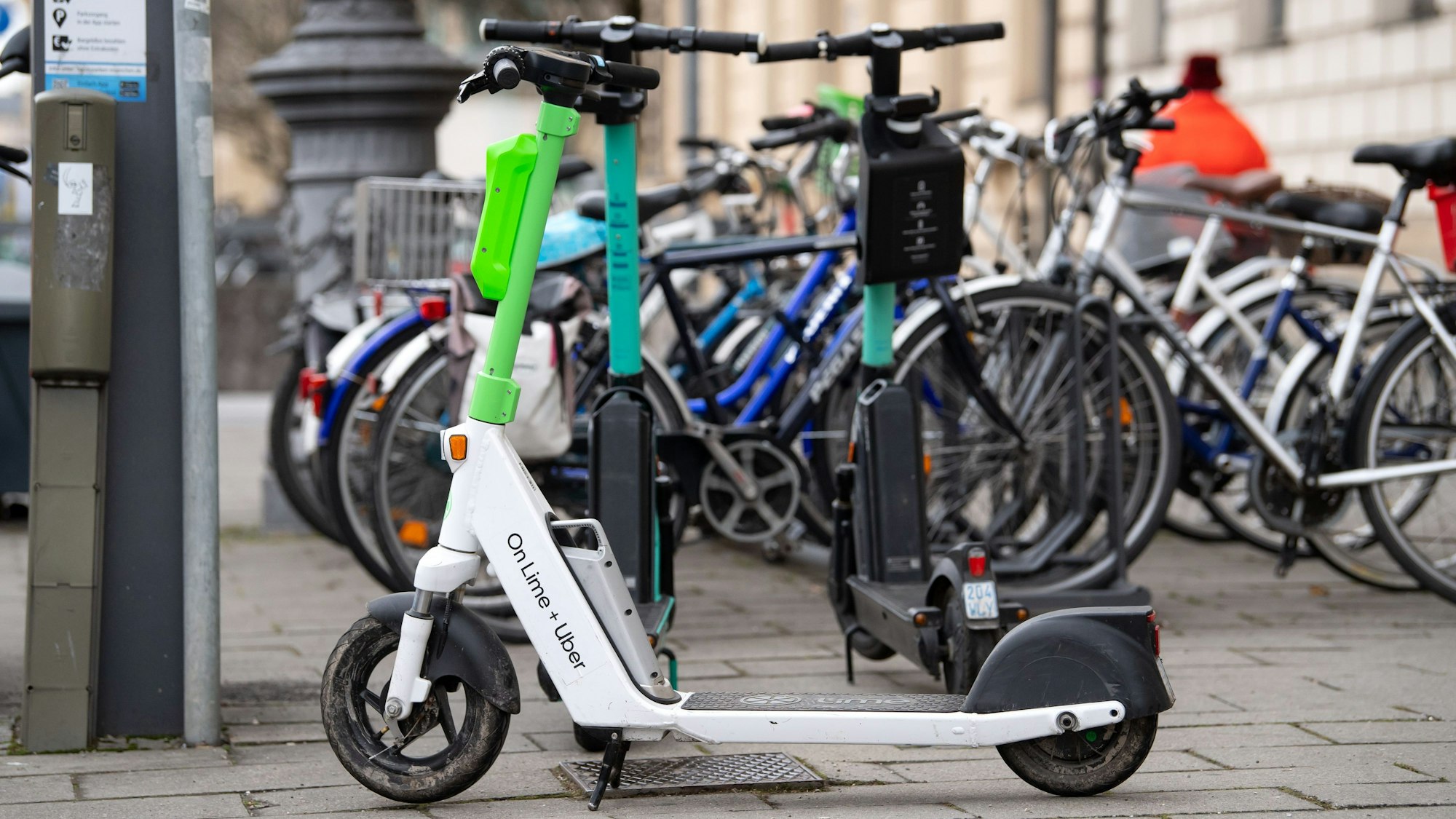 E-Scooter stehen in der Innenstadt auf einem Gehweg.