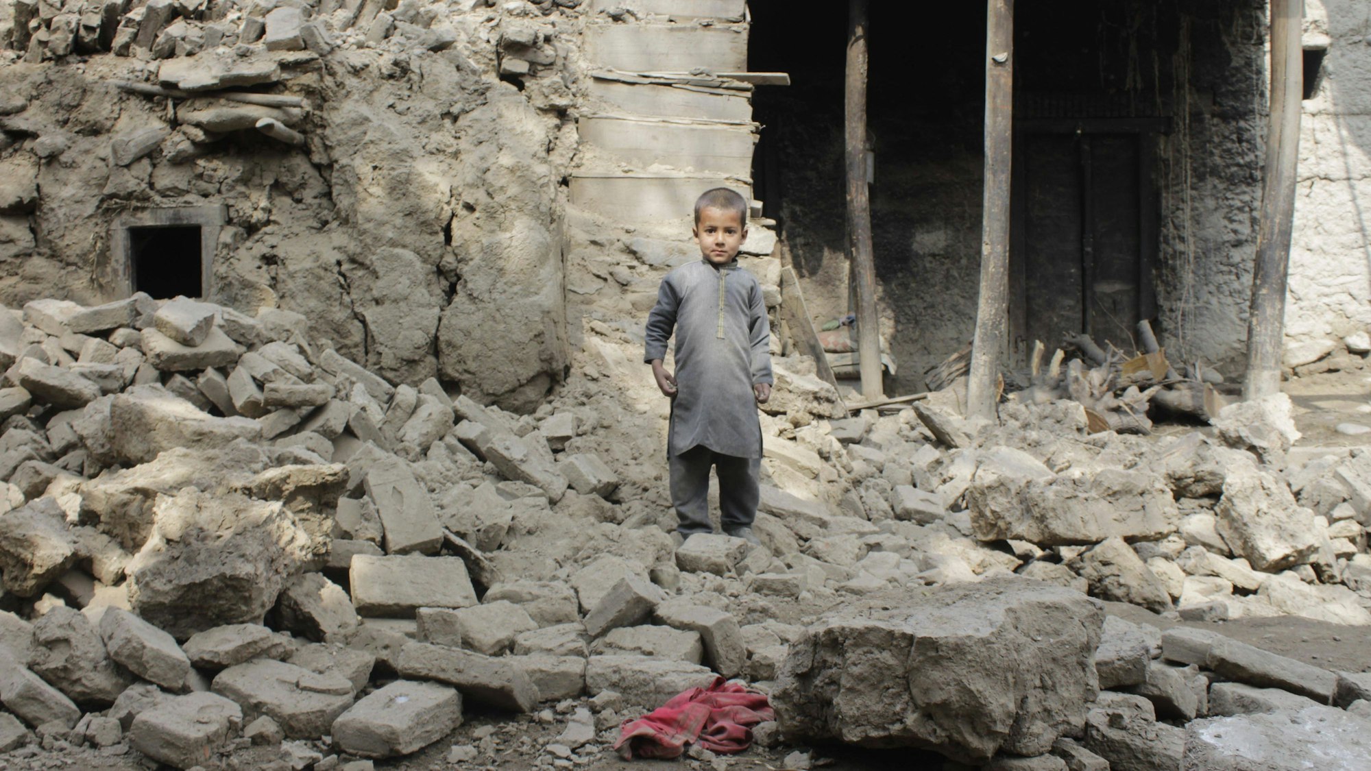 Ein Kind steht in den Trümmern eines durch ein Erdbeben zerstörtes Haus in der Provinz Laghman in Afghanistan.