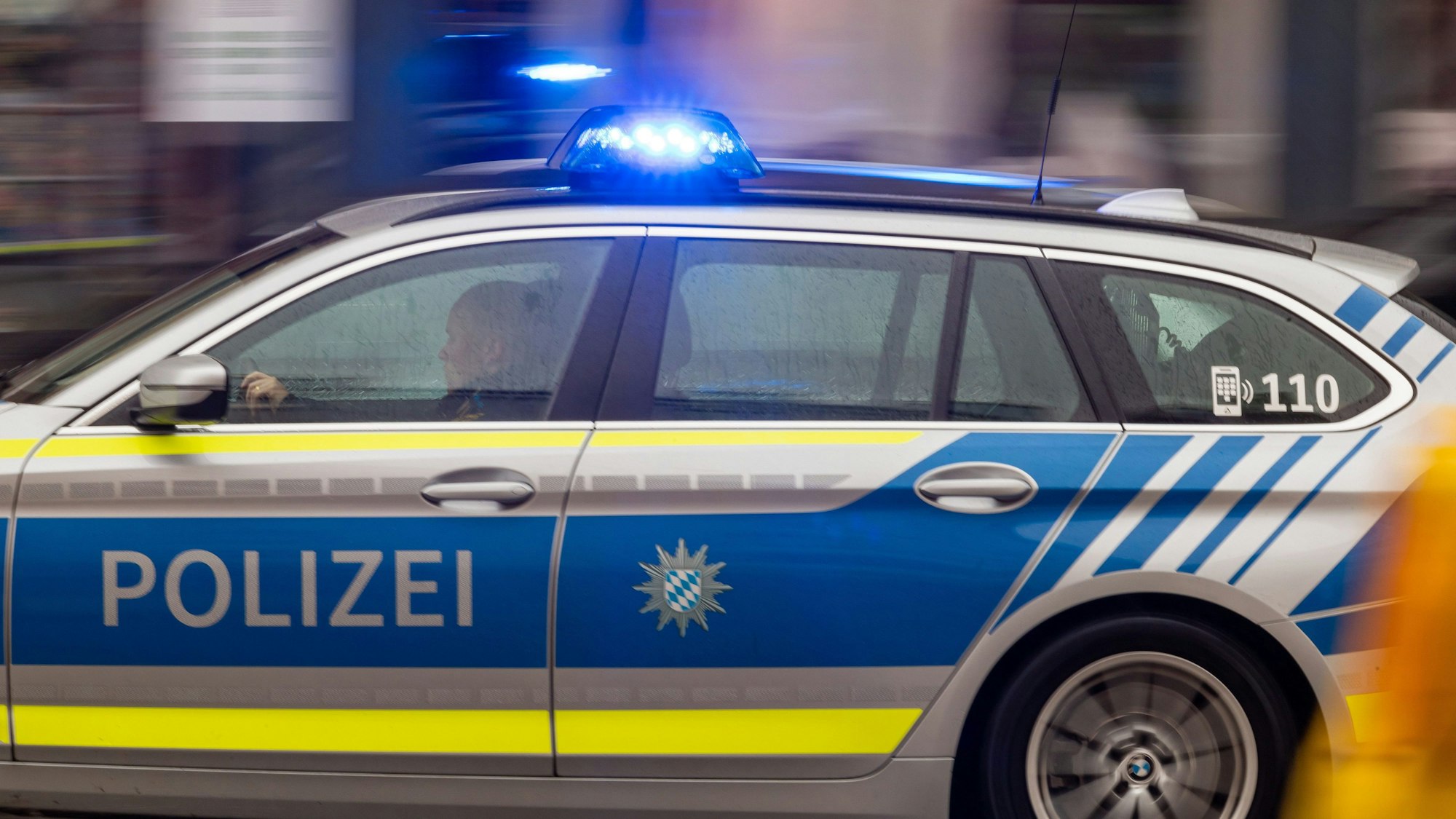 Ein Polizeiwagen fährt mit Blaulicht durch die Innenstadt.