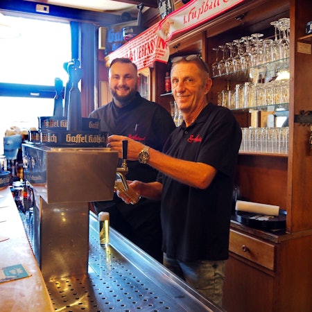 Die zwei Inhaber des neuen Restaurants in Zollstock, Jérôme Lottner und Ralf Klein, stehen hinter dem Tresen aus Holz an der Zapfanlage.