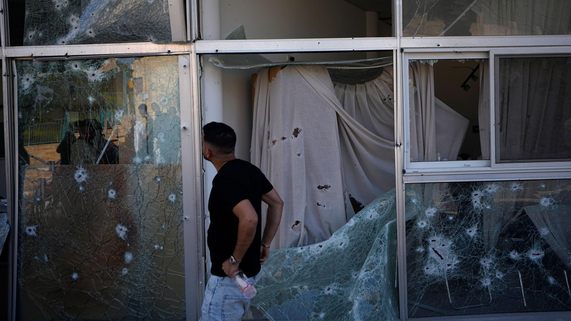 Ein Mann in Shlomi (Nordisrael) schaut sich die Schäden an einem Geschäft an, die durch abgefangenes Raketenfeuer entstanden sind.