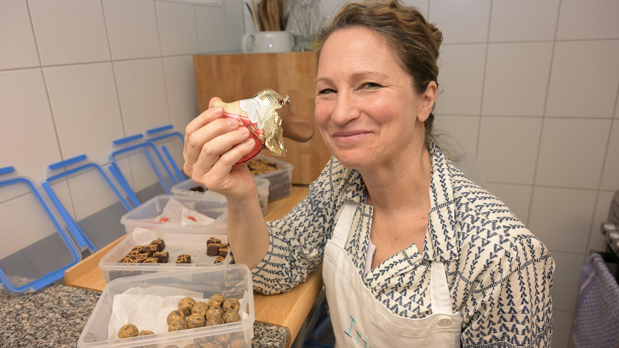 Irina Wilbrand sitzt am Tisch und hält einen Schokohasen in die Höhe.