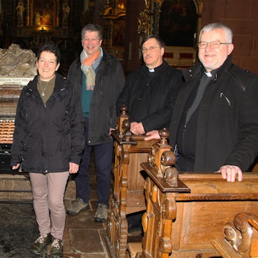 Das Pastoralteam um Wieslaw Kaczor (r.) steht am Grab des Eifel-Heiligen in der Steinfelder Basilika.