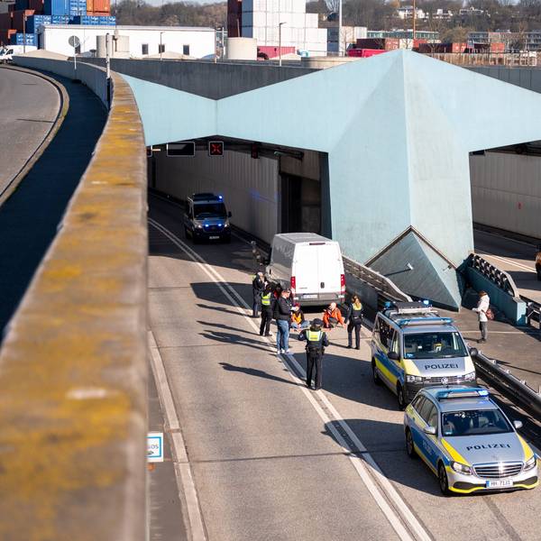 Klimaaktivisten haben sich auf der Fahrbahn der Autobahn 7 festgeklebt und blockieren so die Zufahrt des Elbtunnels in Richtung Norden. Foto: Daniel Bockwoldt/dpa +++ dpa-Bildfunk +++