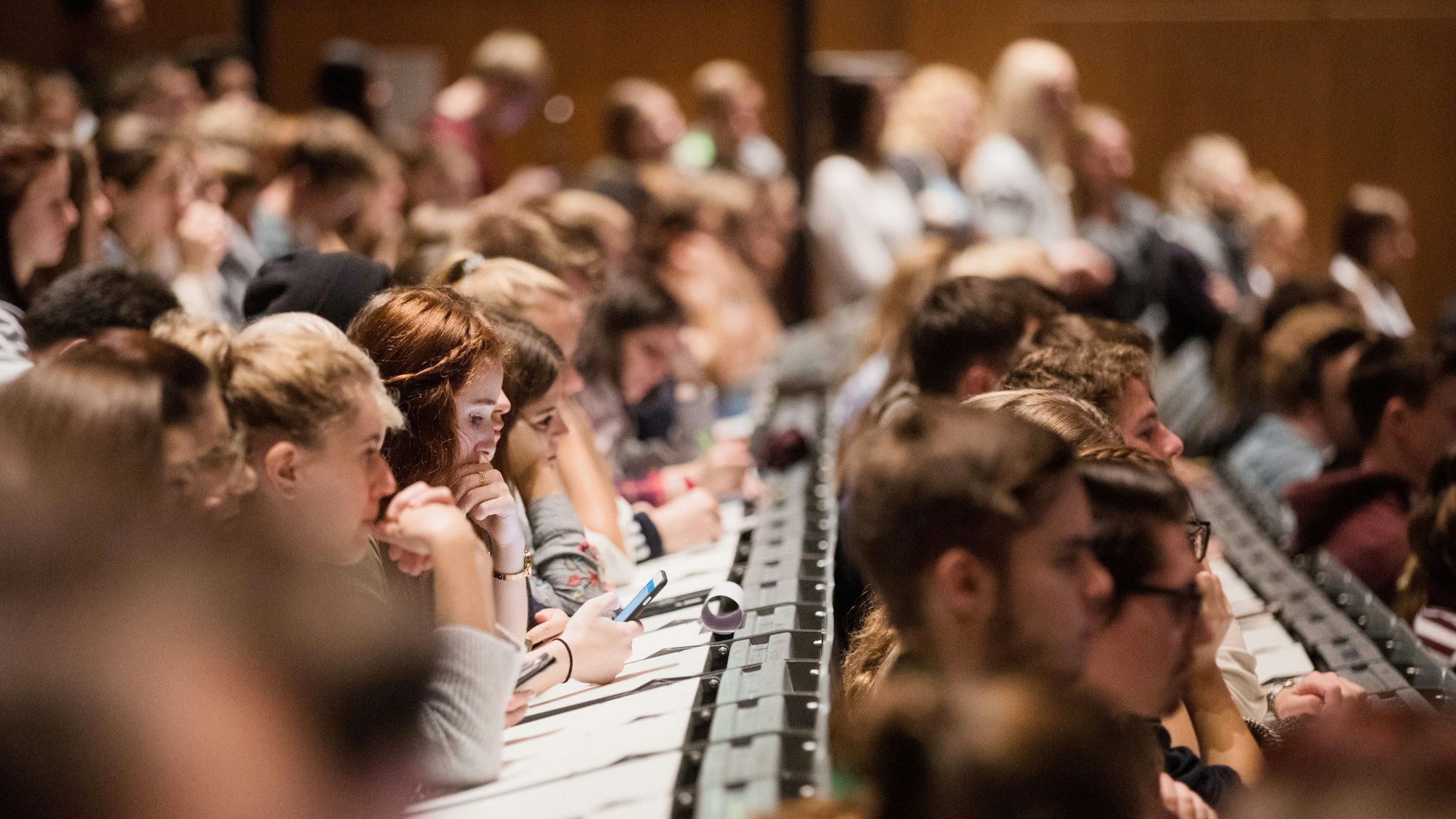 ARCHIV - 09.10.2017, Nordrhein-Westfalen, Köln: Studenten verfolgen im Hörsaal im Hauptgebäude der Kölner Universität die Erstsemesterbegrüßung.