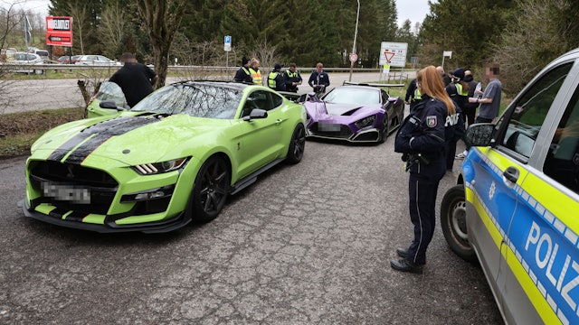 Zwei Sportwagen aus den Niederlanden sind von Polizisten herausgewunken worden und werden auf einem Parkplatz in Losheim kontrolliert.