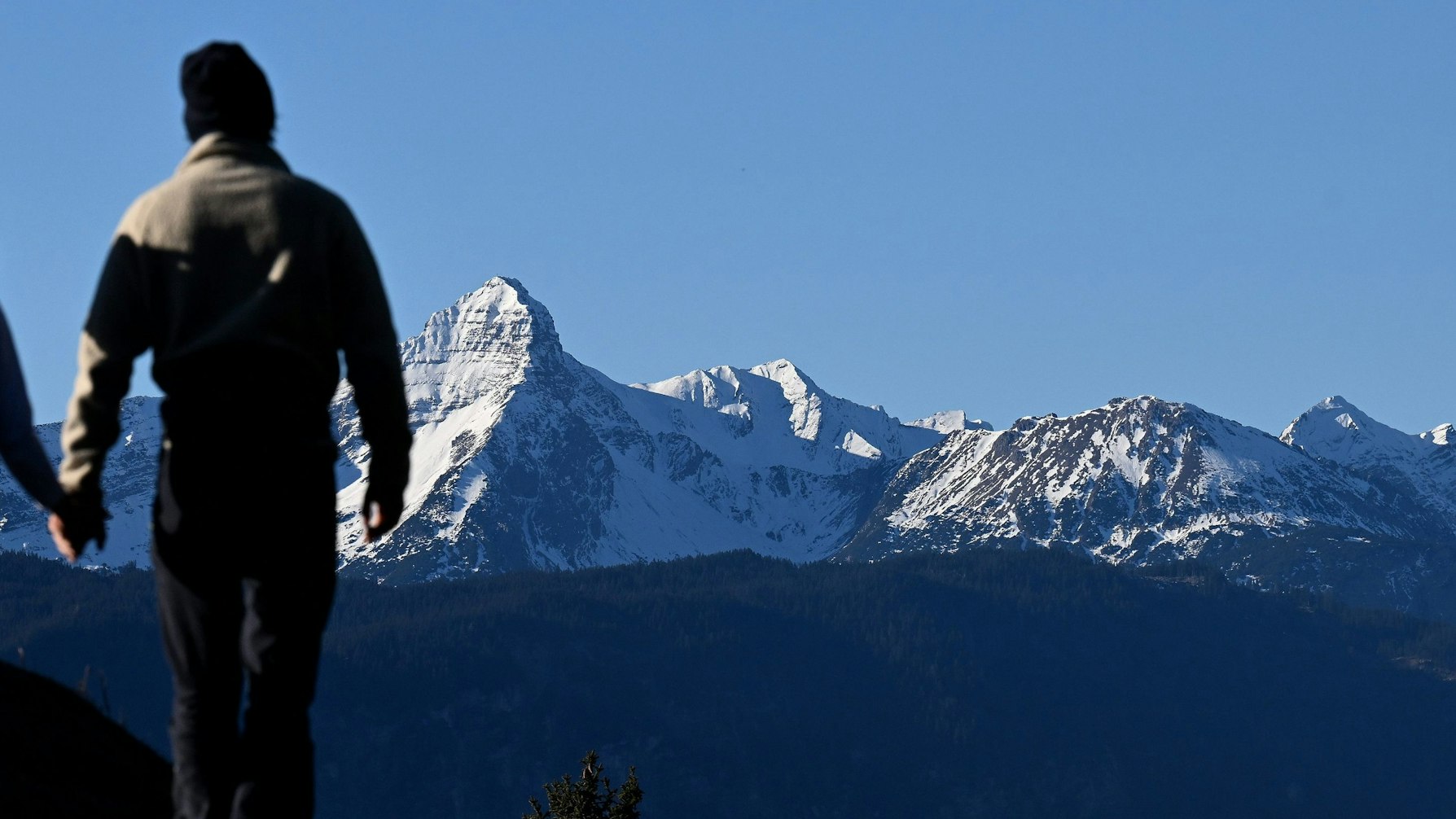 Verschneit zeigt sich der Gipfel des Daniel vor zwei Wanderern. In den deutschen Alpen sind zur Jahreswende weniger Touristen angekommen als vor der Corona-Pandemie. 878 000 Übernachtungsgäste in den Monaten Dezember 2022 und Januar 2023 bedeuteten ein Minus von knapp 13 Prozent gegenüber dem gleichen Zeitraum 2019/2020, wie das Statistische Bundesamt am Dienstag berichtete (zu dpa «Tourismus in den Alpen: Immer noch weniger Gäste als vor Corona»)