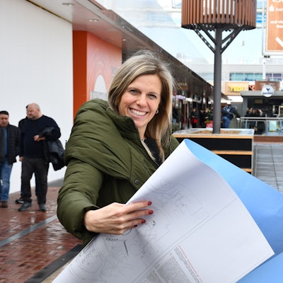 Das Bild zeigt die Center-Managerin Alexandera Oeser im Hürth-Park mit einer Zeichnung der Umbaupläne.