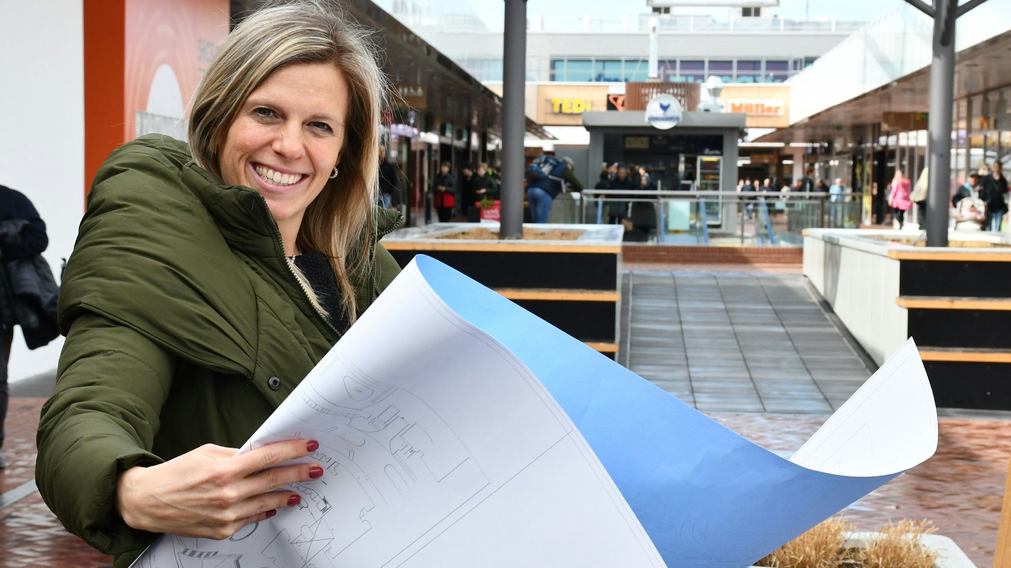 Das Bild zeigt die Center-Managerin Alexandera Oeser im Hürth-Park mit einer Zeichnung der Umbaupläne.