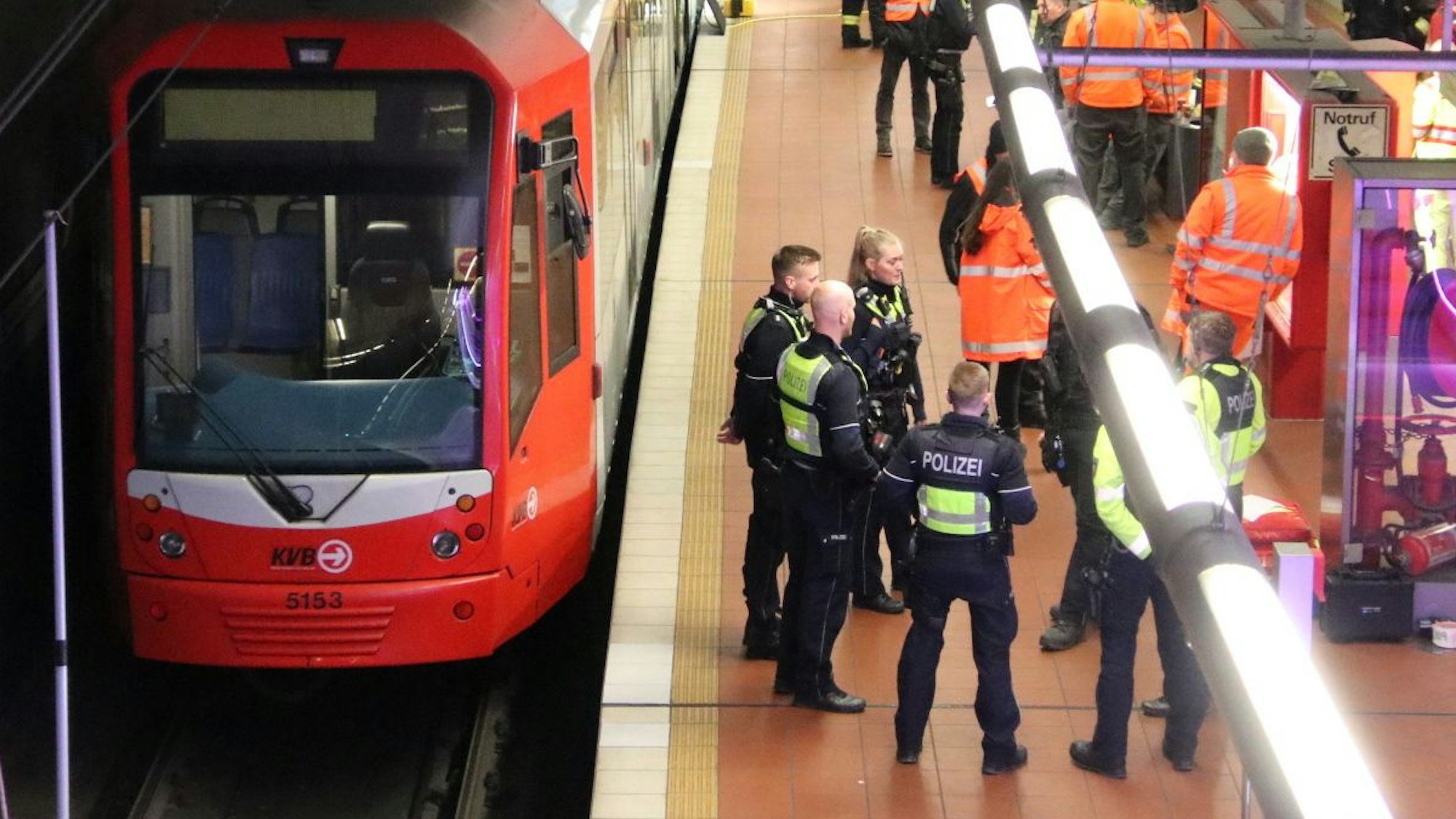 Rettungskräfte und Polizeibeamte stehen am Donnerstagabend an der KVB-Haltestelle Akazienweg. Zuvor war es zu einem tödlichen Unfall gekommen.
