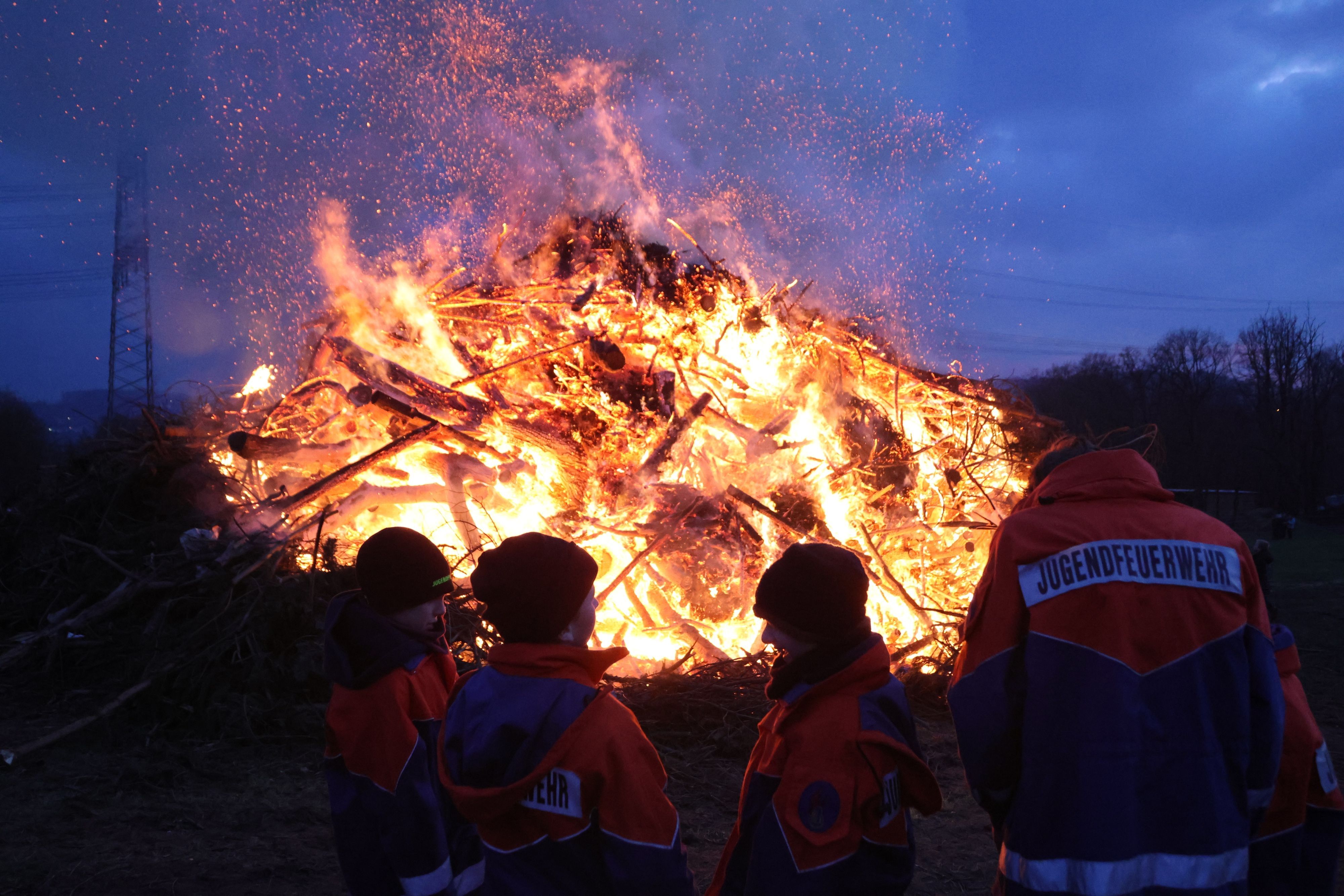Das Osterfeuer in Heischeid brennt in der Abenddämmerung.