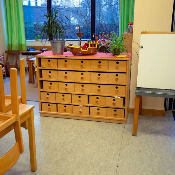 Blick in den Raum einer Kindertagesstätte mit hochgestellten Stühlen.