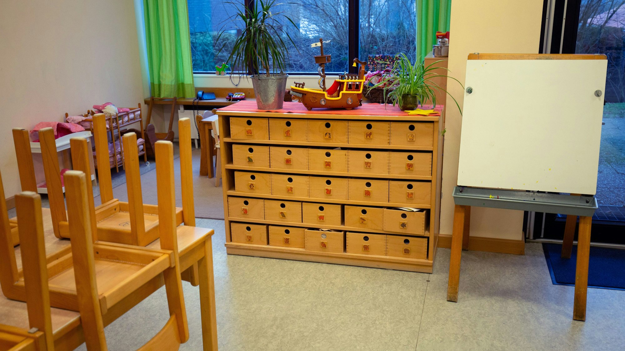 Blick in den Raum einer Kindertagesstätte mit hochgestellten Stühlen.