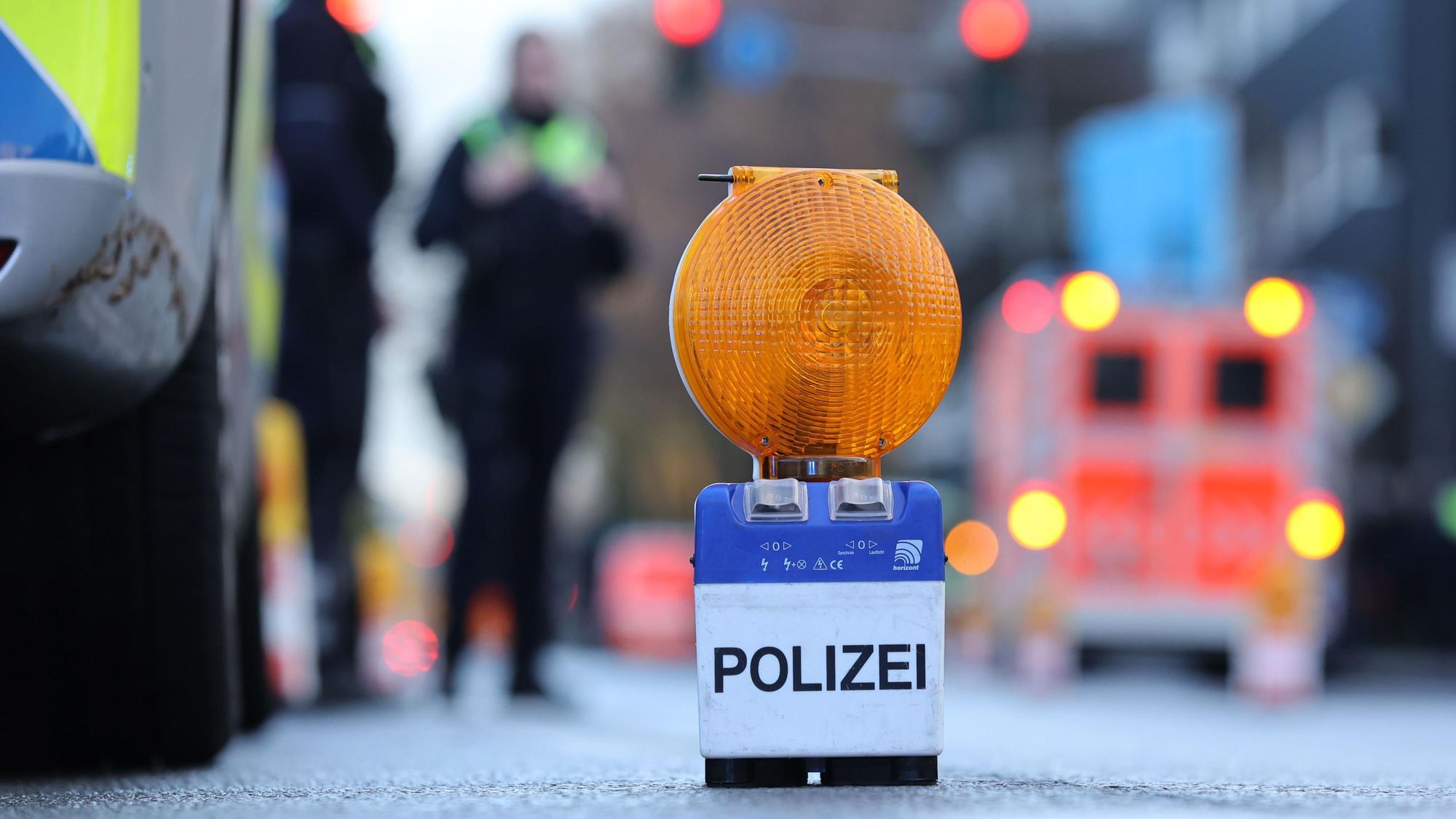 Eine Polizei-Warnbake auf Aachener Str. in Köln. Im Hintergrund ist ein Rettungswagen zu sehen. (Symbolbild)
