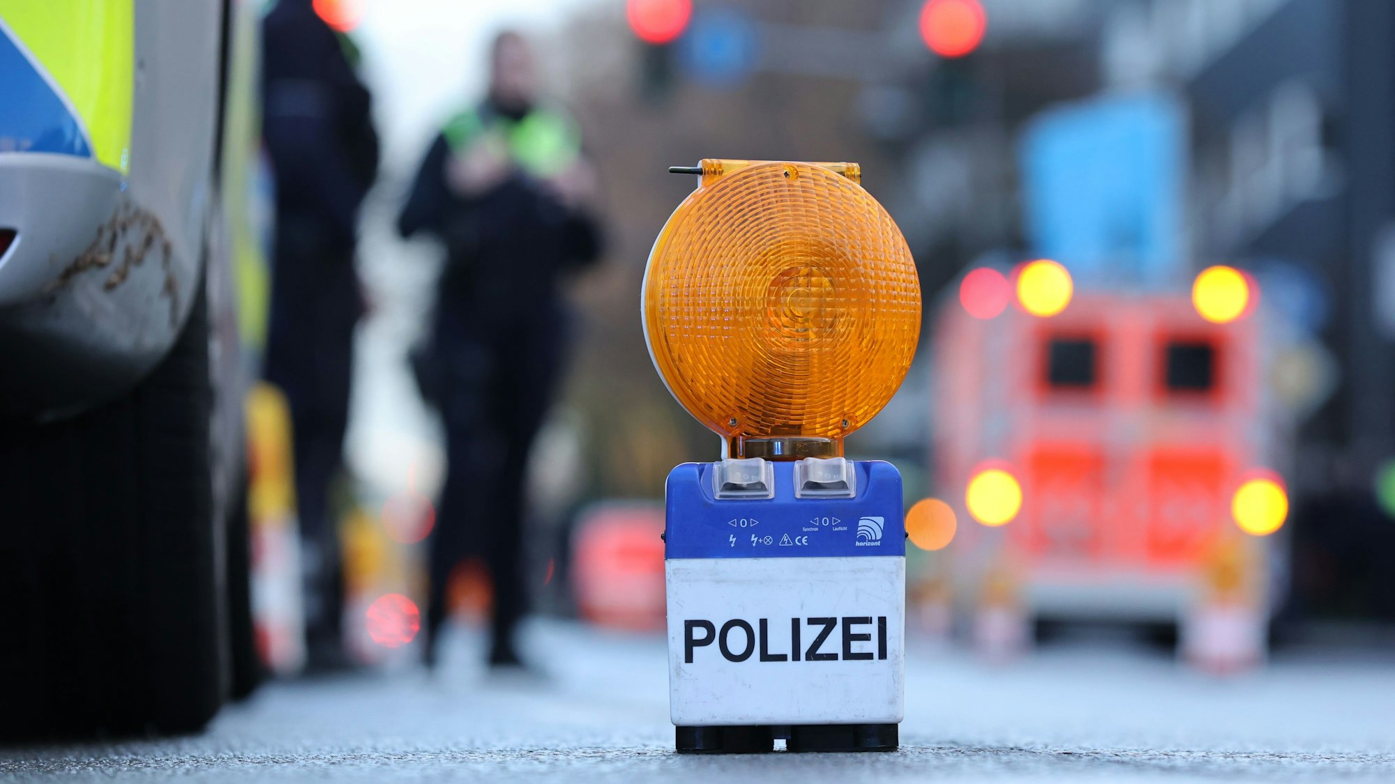 Eine Polizei-Warnbake auf Aachener Str. in Köln. Im Hintergrund ist ein Rettungswagen zu sehen. (Symbolbild)