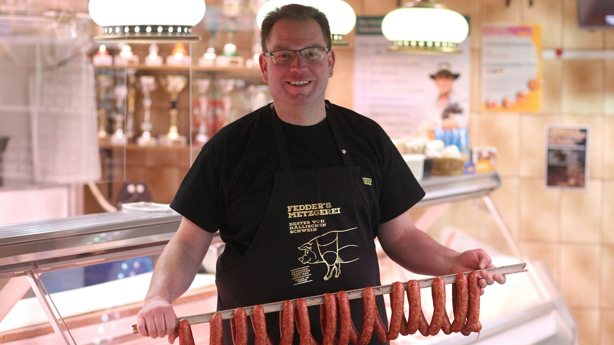 Wurst Metzger Daniel Fedder aus Much vor seiner Ladentheke.