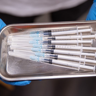 Aufgezogene Spritzen mit Impfstoff gegen Covid-19 liegen in einem temporären mobilen Impfzentrum in einer Schale.