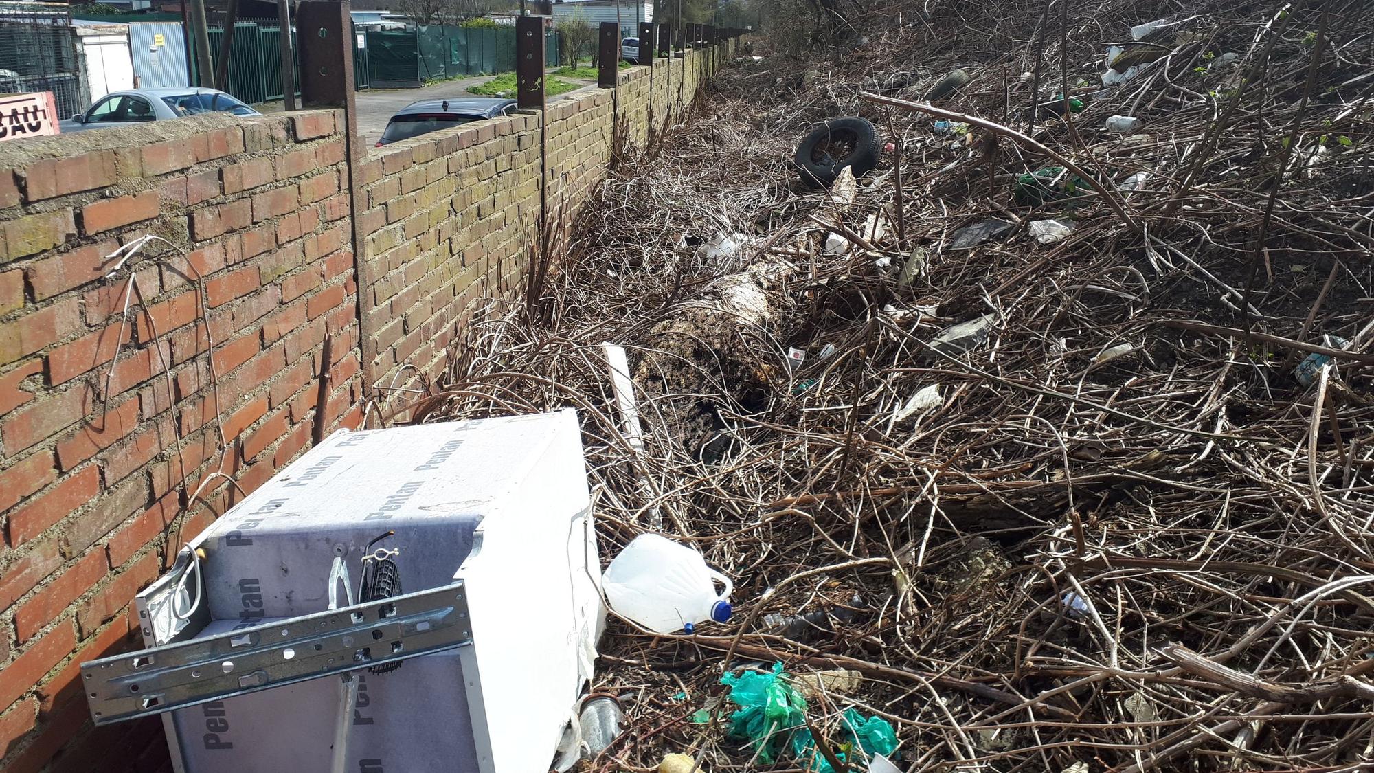 Eine alte Waschmaschine, Plastikkanister, Autoreifen und sonstiger Unrat türmt sich hinter einer Bahndamm-Mauer an der Etzelstraße.