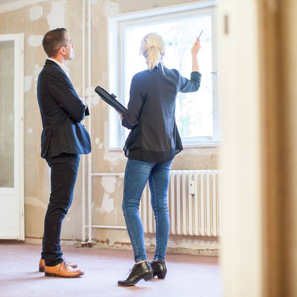 Eine Immobilienmaklerin zeigt einem Interessenten eine Wohnung.