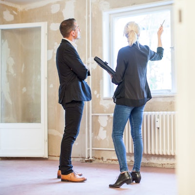 Eine Immobilienmaklerin zeigt einem Interessenten eine Wohnung.