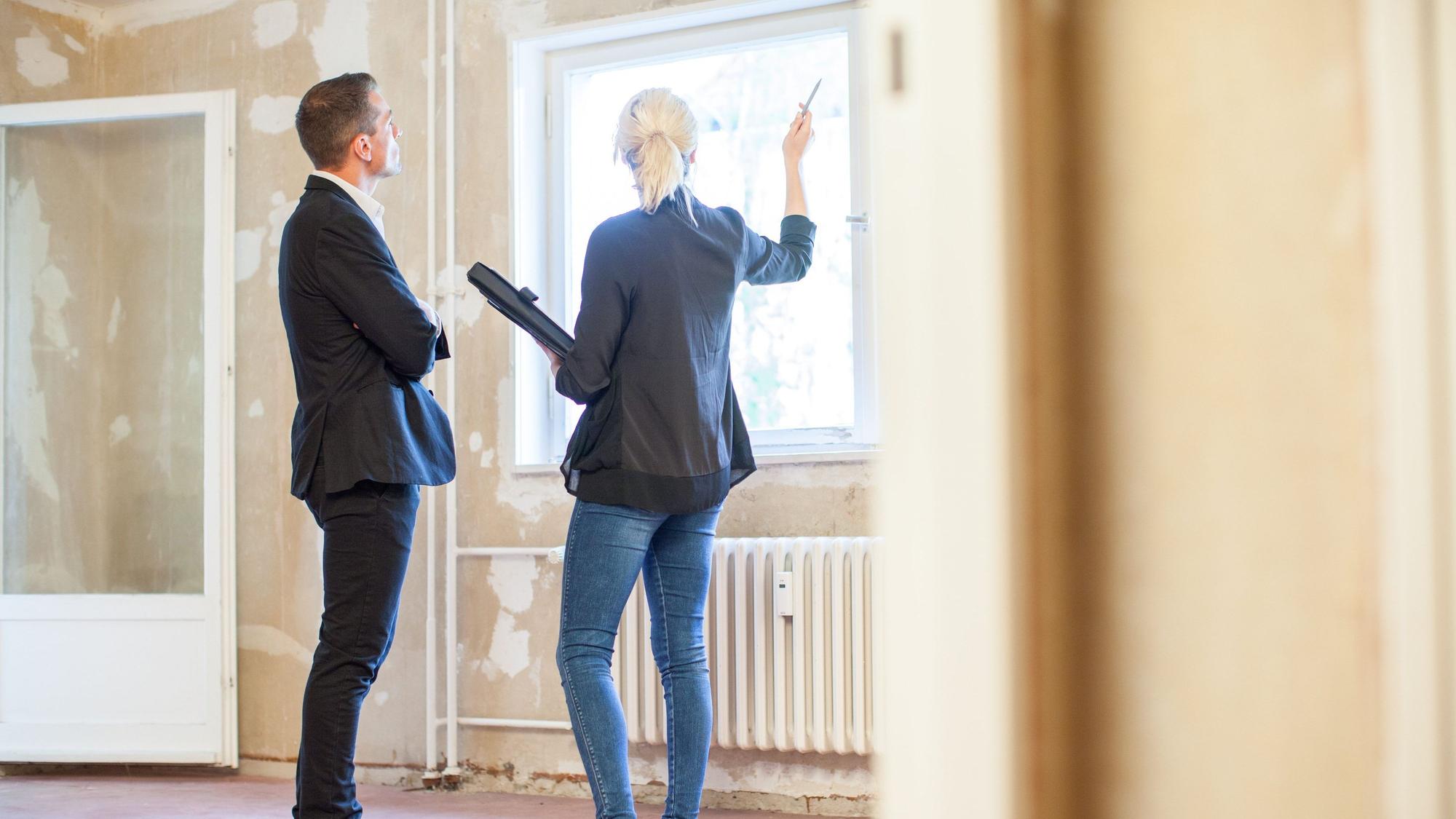 Eine Immobilienmaklerin zeigt einem Interessenten eine Wohnung.