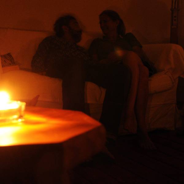 Ein Paar sitzt während eines Stromausfalls bei Kerzenschein in einer Wohnung in Hannover.
