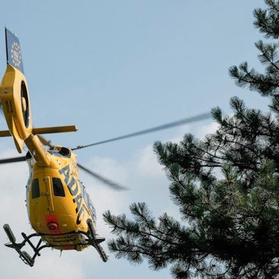 Ein gelber Rettungshubschrauber des ADAC von unten fotografiert.