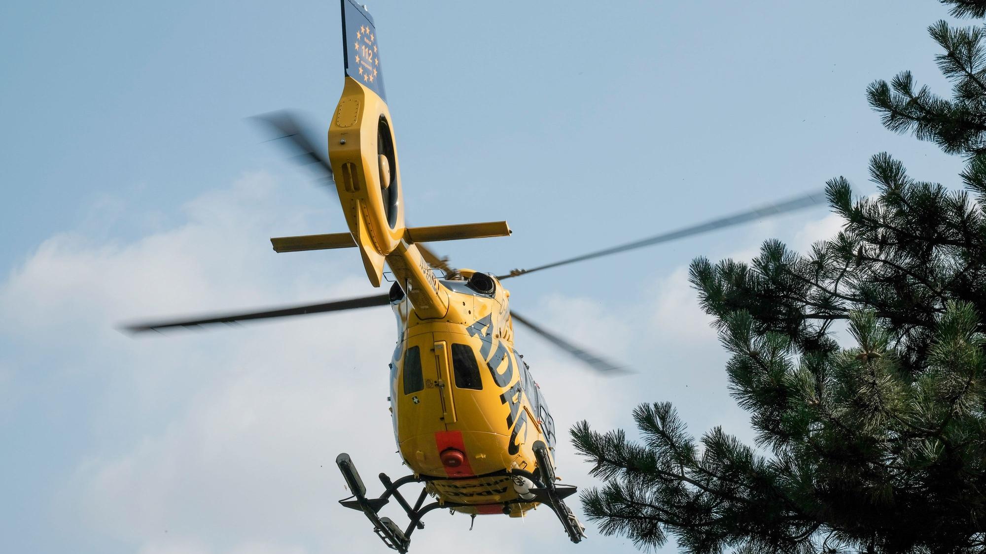 Ein gelber Rettungshubschrauber des ADAC von unten fotografiert.