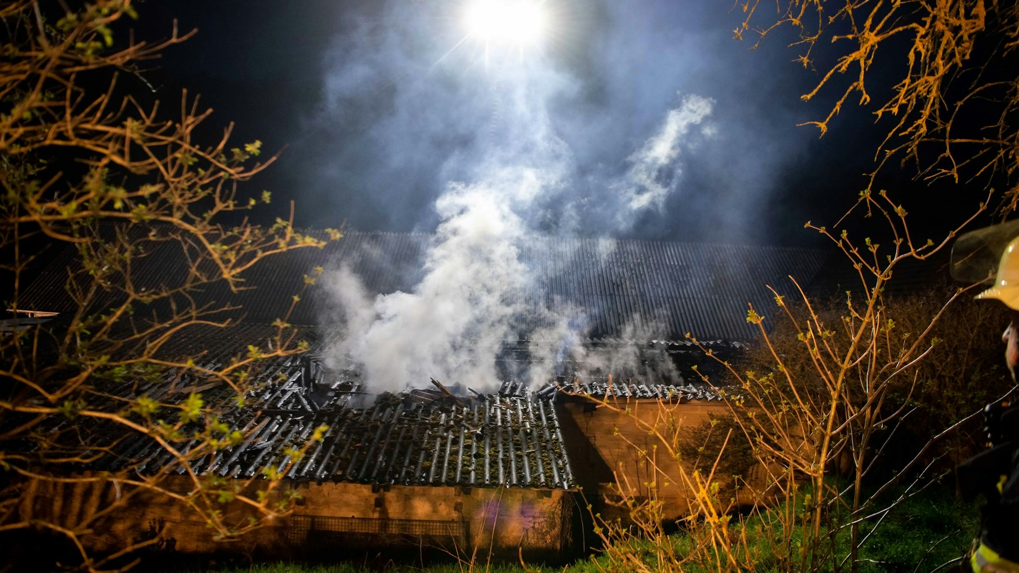 Aus dem Dach eines Stalls steigt Rauch auf. Darüber ist eine große Leuchte.