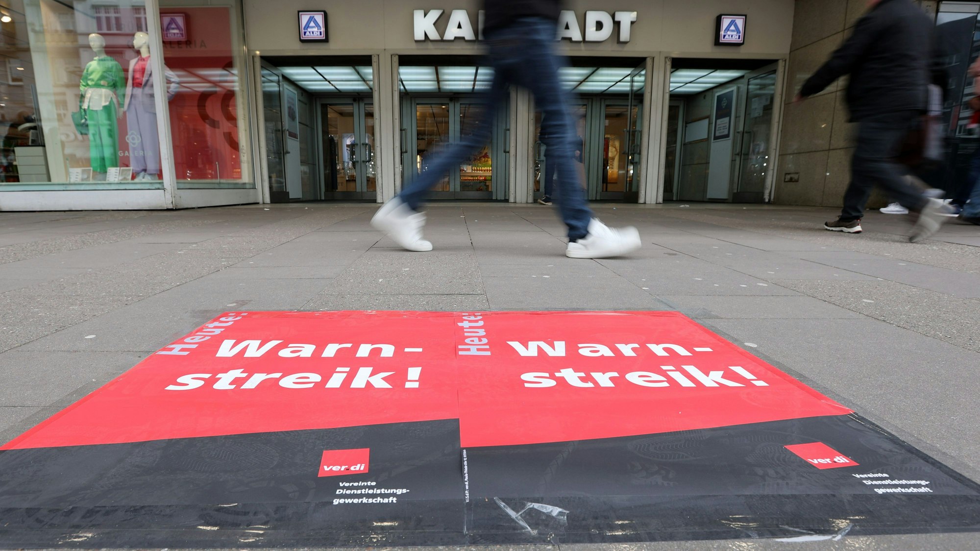 Plakate mit der Aufschrift "Warnstreik" sind vor einem Galeria-Karstadt-Kaufhaus in der Osterstraße in Hamburg zu sehen.