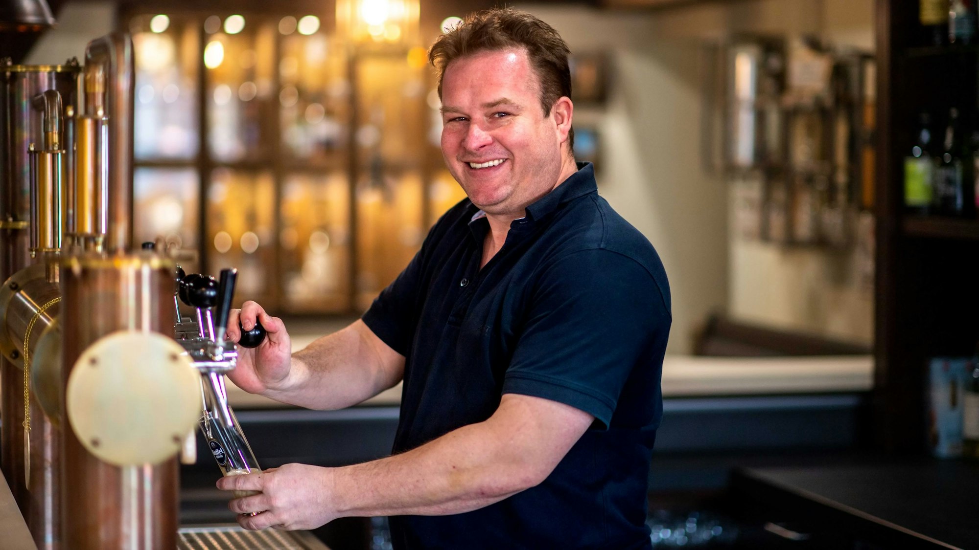 Stollen-Betreiber Michael Schepers zapft ein Bier