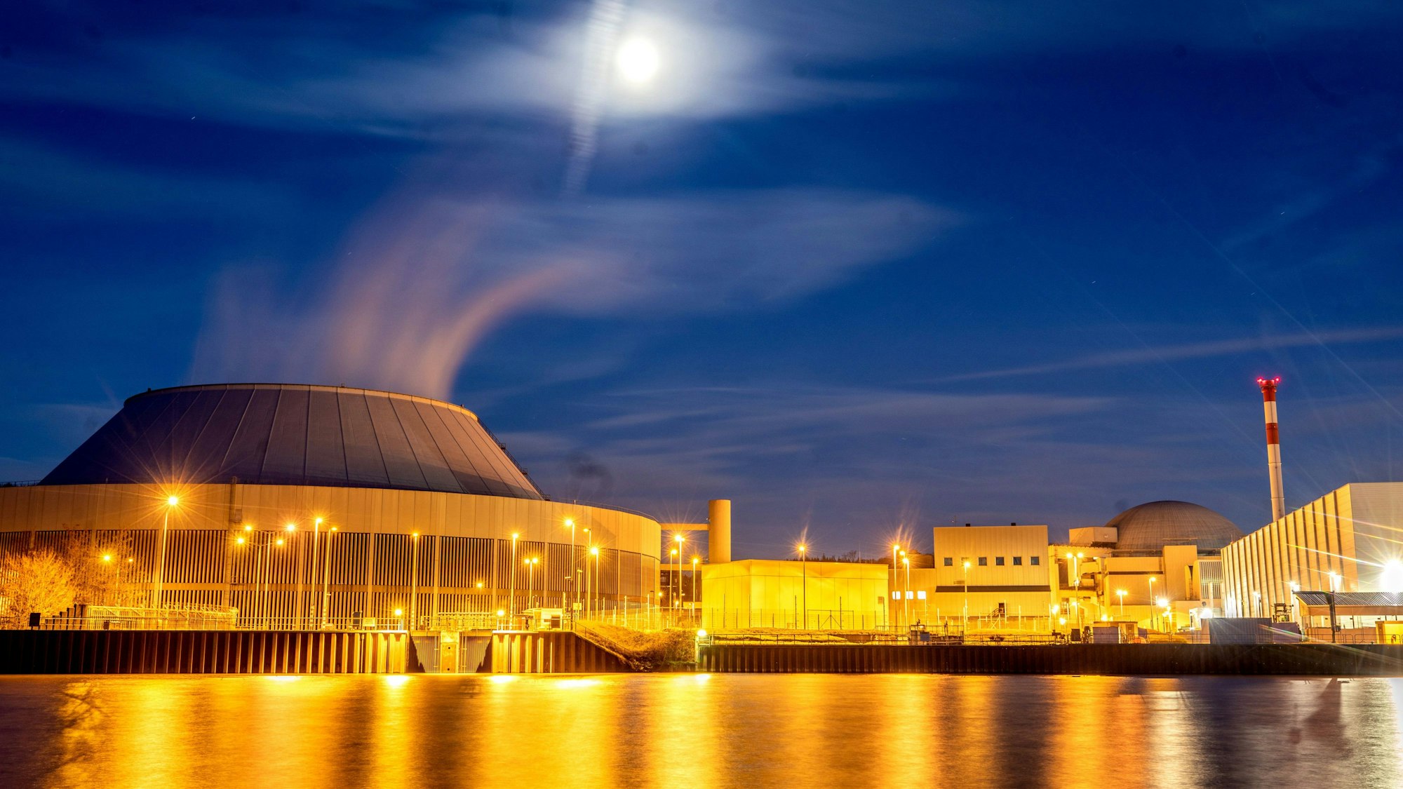 Der Mond leuchtet zur blauen Stunde über dem Kernkraftwerk Neckarwestheim.