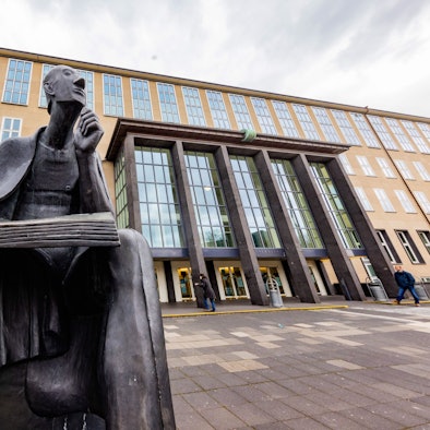 In Denkerpose thront der Gelehrte Albertus Magnus vor dem Hauptgebäude der Universität.