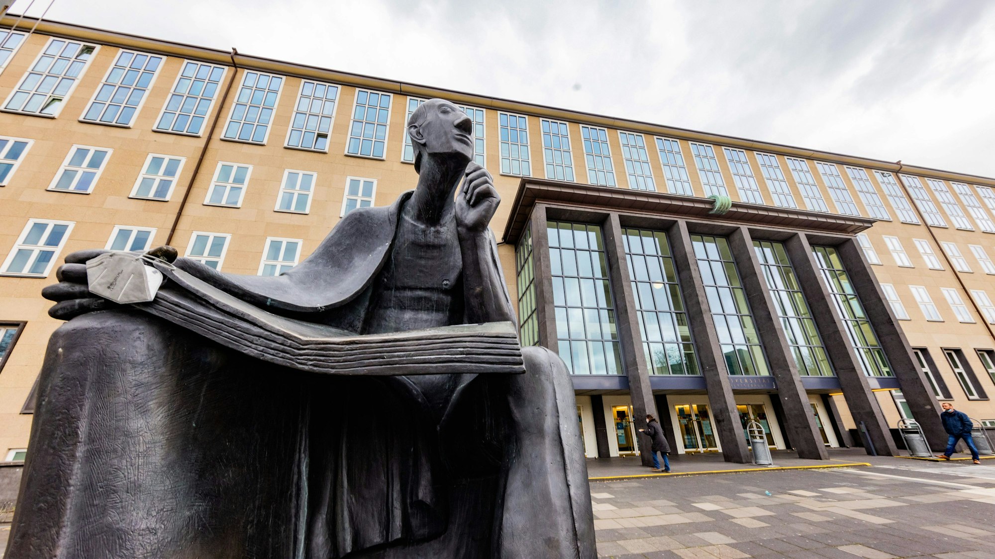 In Denkerpose thront der Gelehrte Albertus Magnus vor dem Hauptgebäude der Universität.