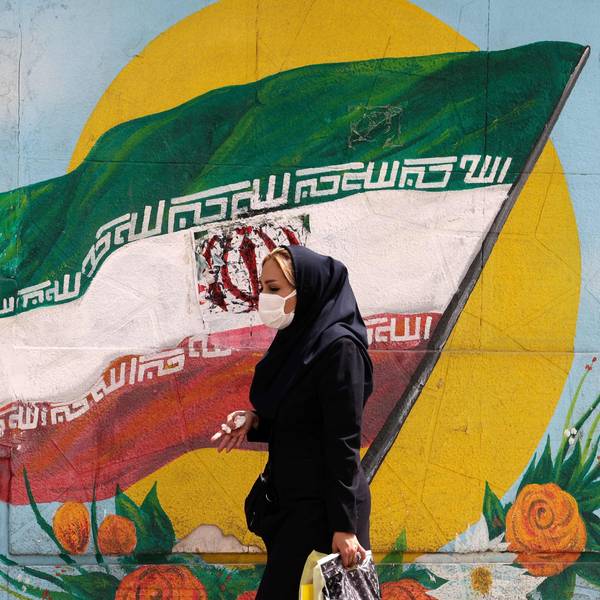 Frau läuft vor iranischer Flagge