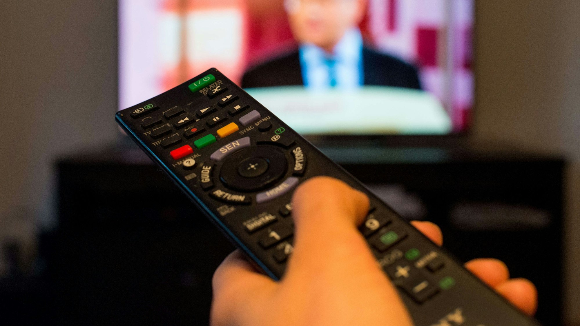 Eine Frau sitzt am 27.09.2016 vor einem Fernseher und hält eine Fernbedienung in der Hand (gestellte Szene).