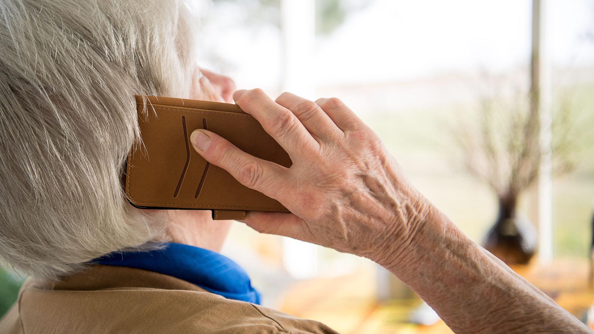 Eine Seniorin telefoniert mit ihrem Smartphone.