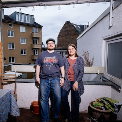 Ein Paar steht auf seinem Balkon.