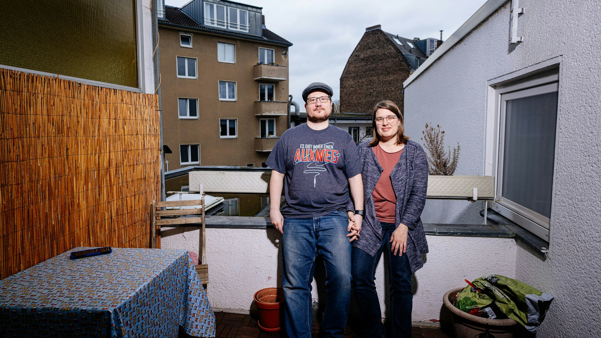 Ein Paar steht auf seinem Balkon.